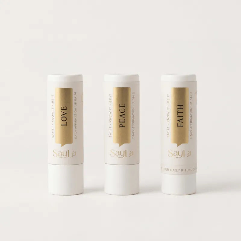 Three lip balms in 'Love', 'Peace', and 'Faith' variant on a white background